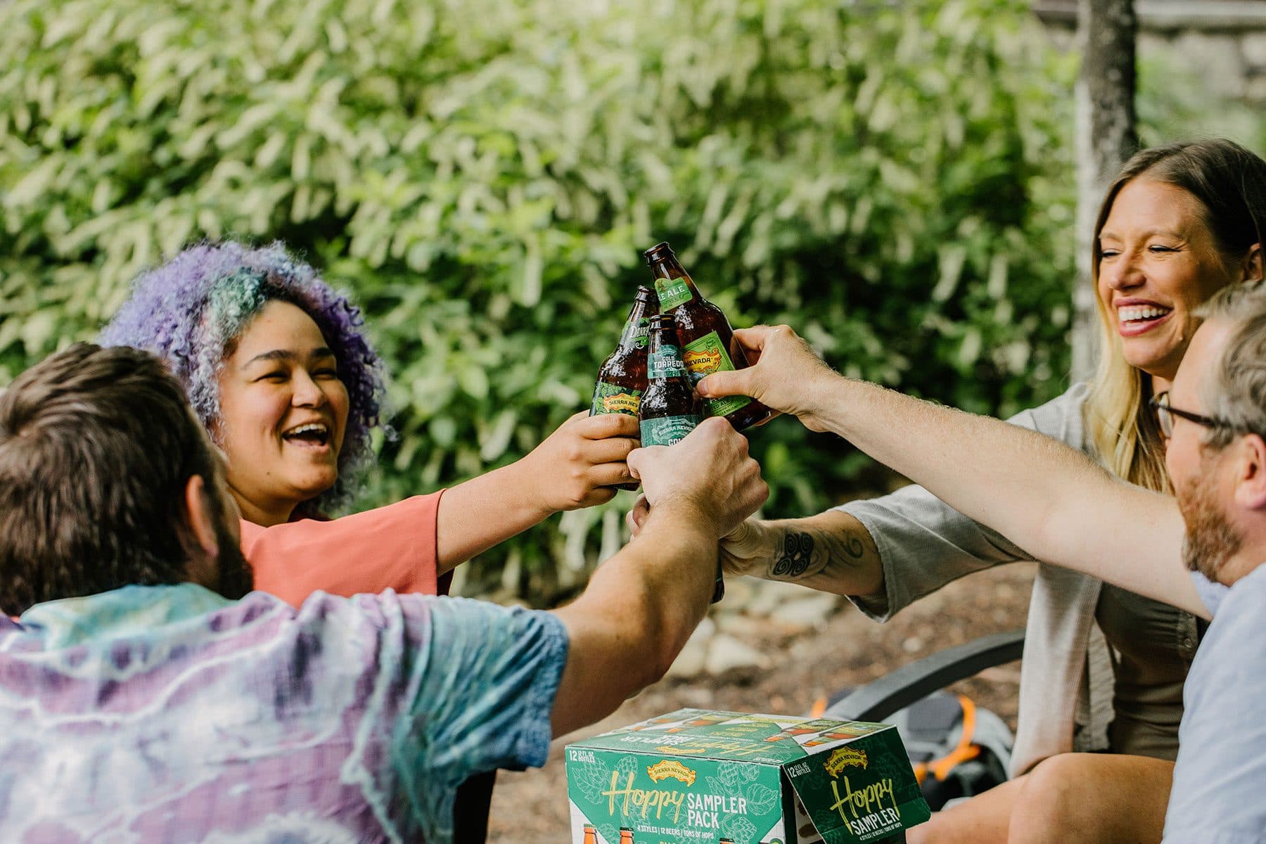 Four friends raising bottles of Sierra Nevada beer in a cheers