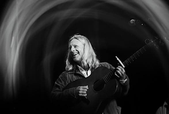 Jon Foreman playing guitar and smiling